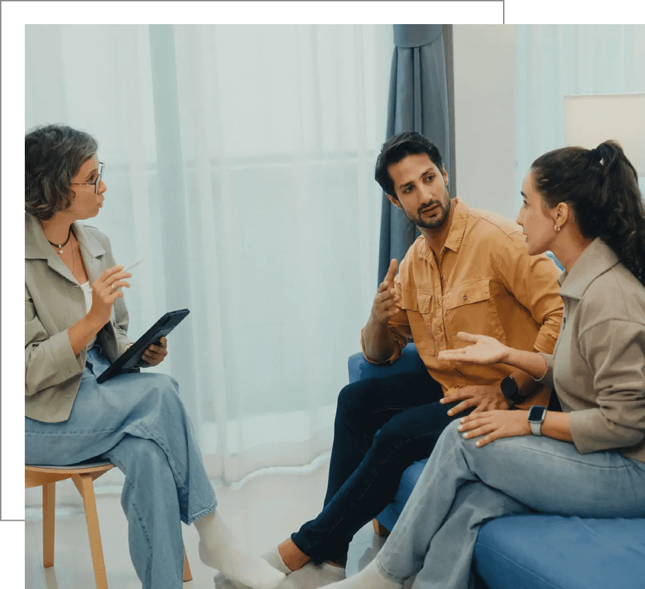 People engaged in a group therapy session with a therapist.