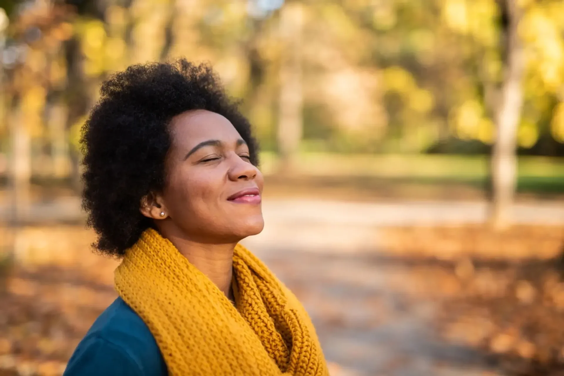 Smiling person in yellow scarf in autumn
